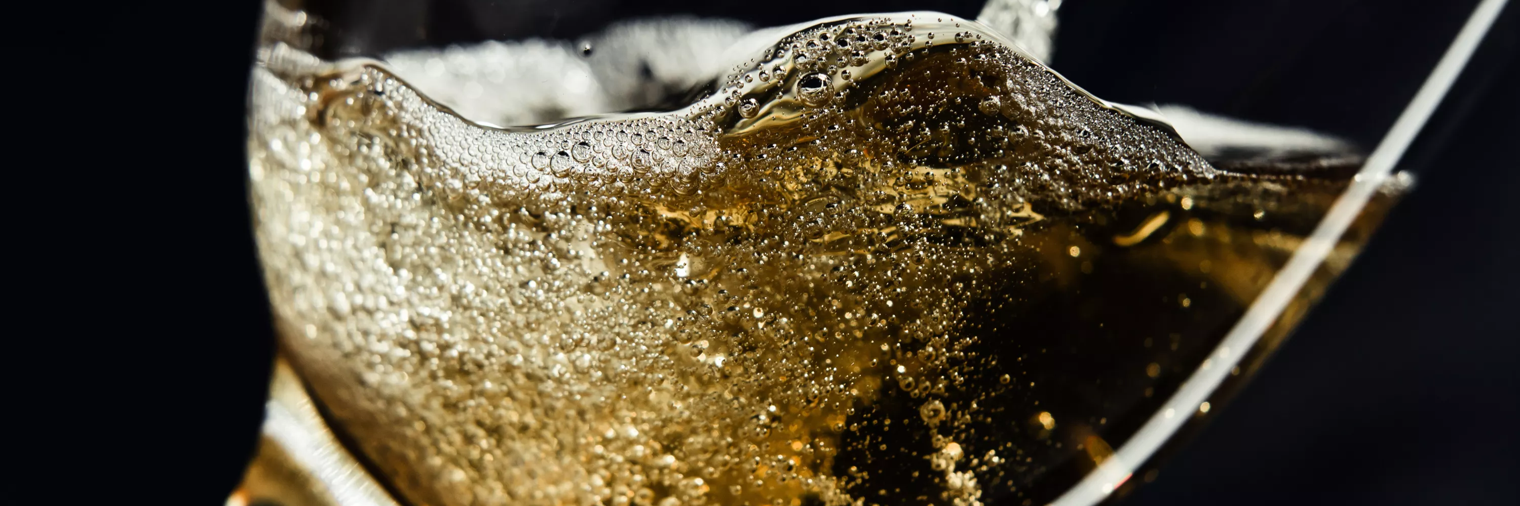 Verre de champagne avec des bulles en effervescence, capturant l’énergie et l’élégance des vins pétillants