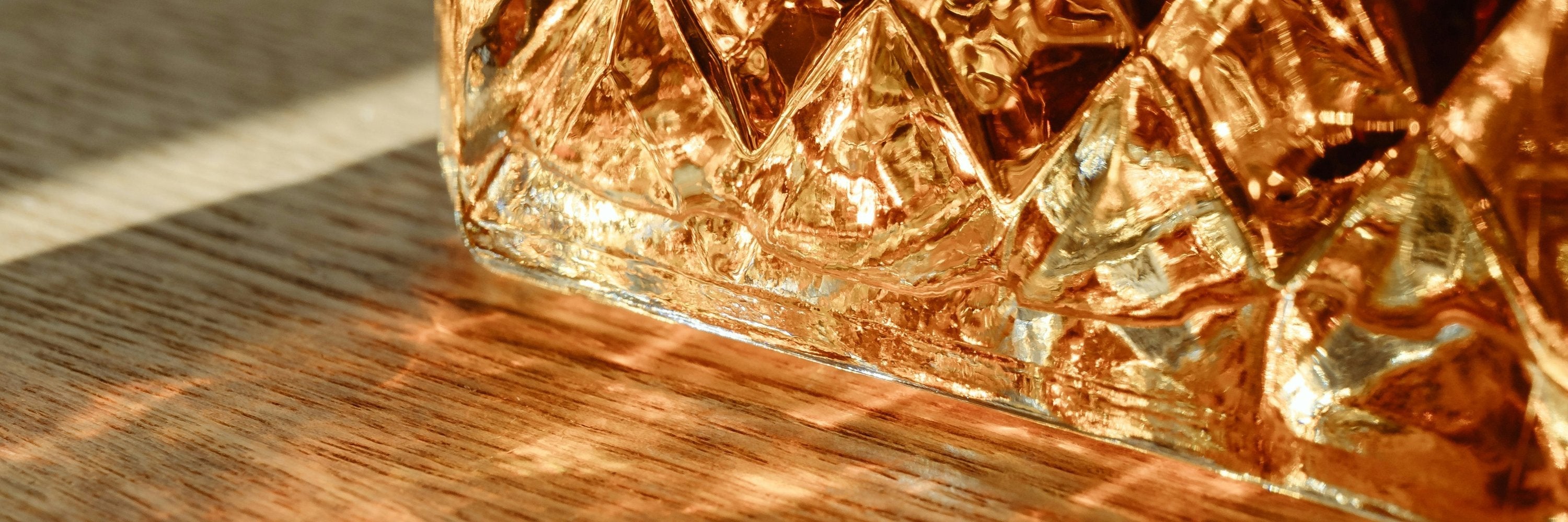 Gros plan sur une bouteille en cristal remplie de whisky ambré, reflétant l’élégance et la qualité du spiritueux